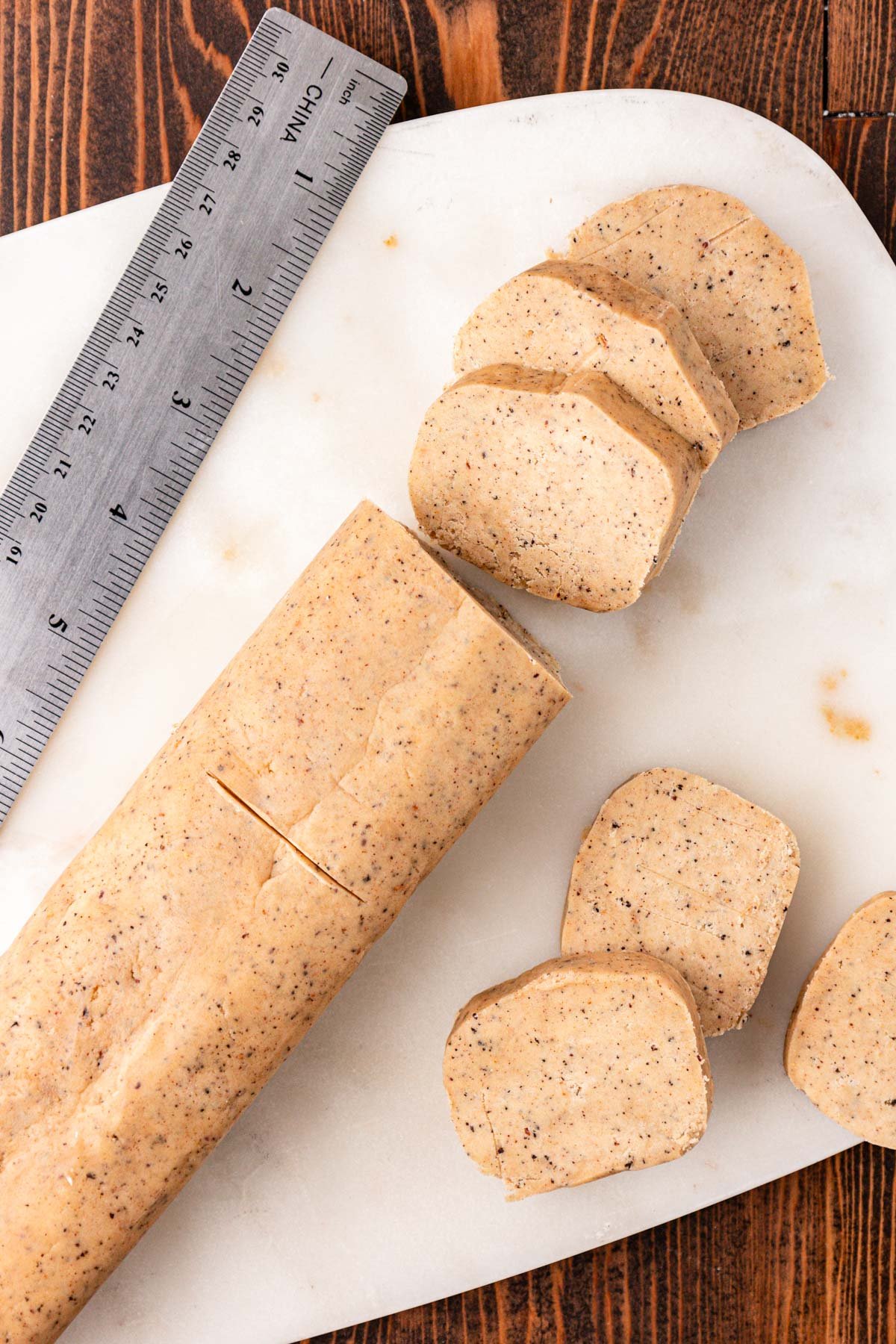 Shortbread slice and bake cookies being cut on a cutting board.