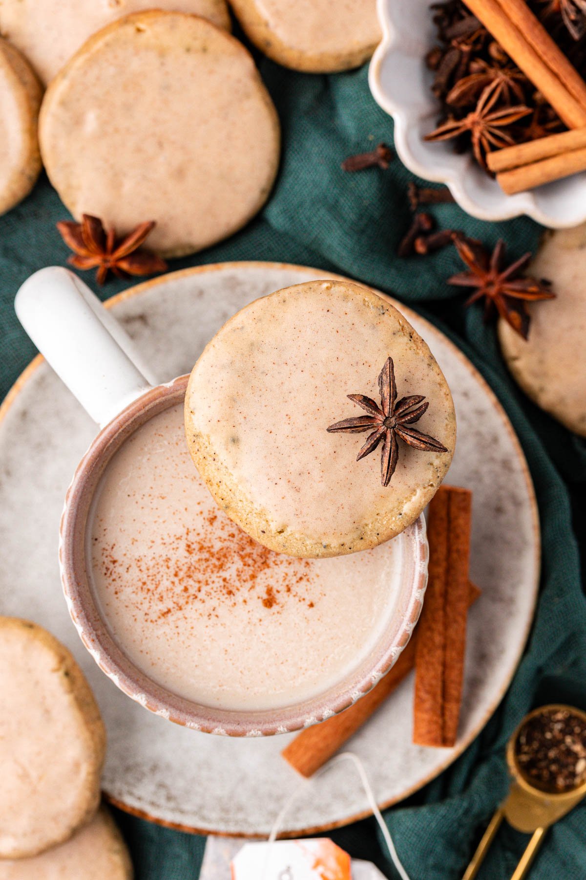 Overhead photo of a mug of chai tea with chai cookies around it.