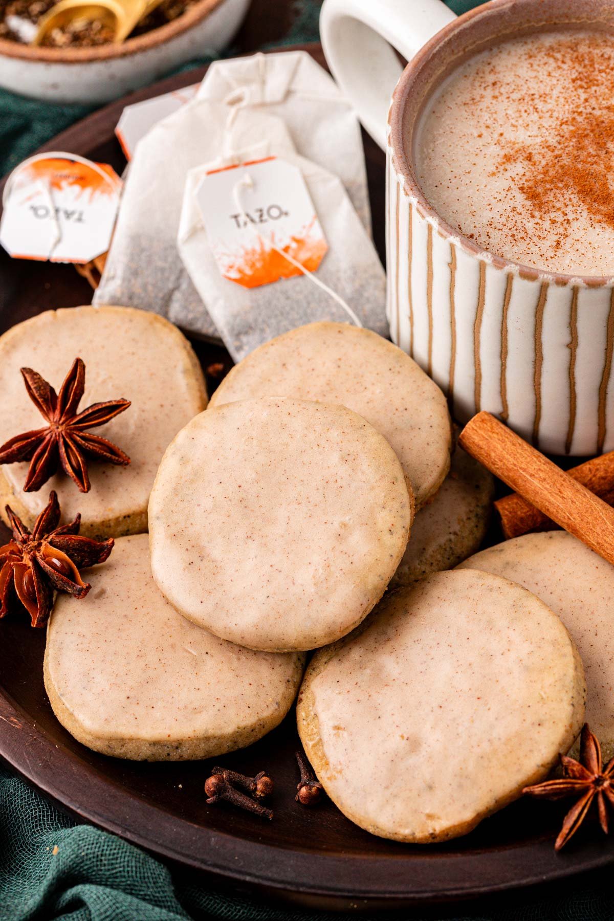 Close up of chai cookies on a plate with a mug of chai.