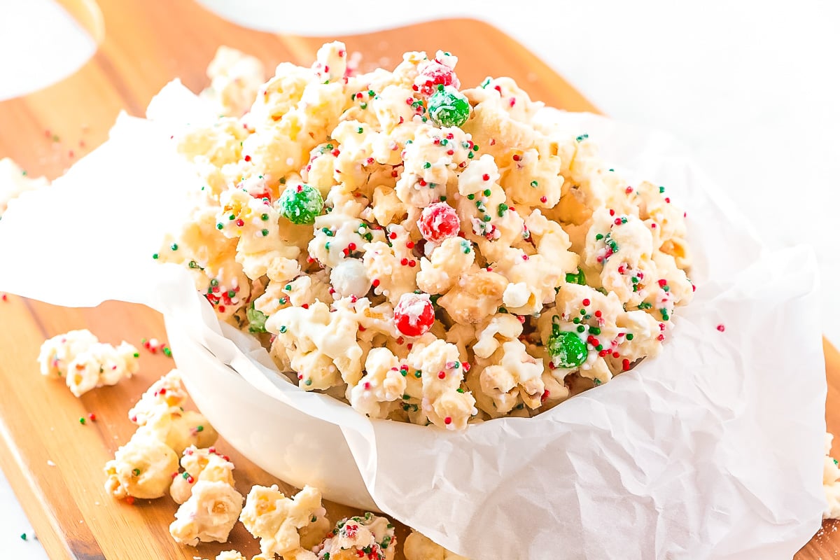 Close up photo of christmas popcorn in a white serving dish.