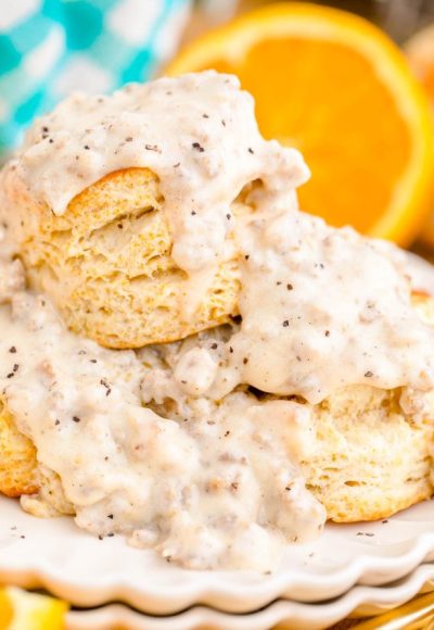 Close up photo of biscuits and sausage gravy on a white plate.