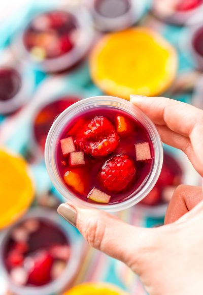 Woman's hand holding a sangria jello shot.