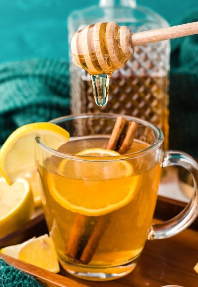 Honey being added to a mug of tea.