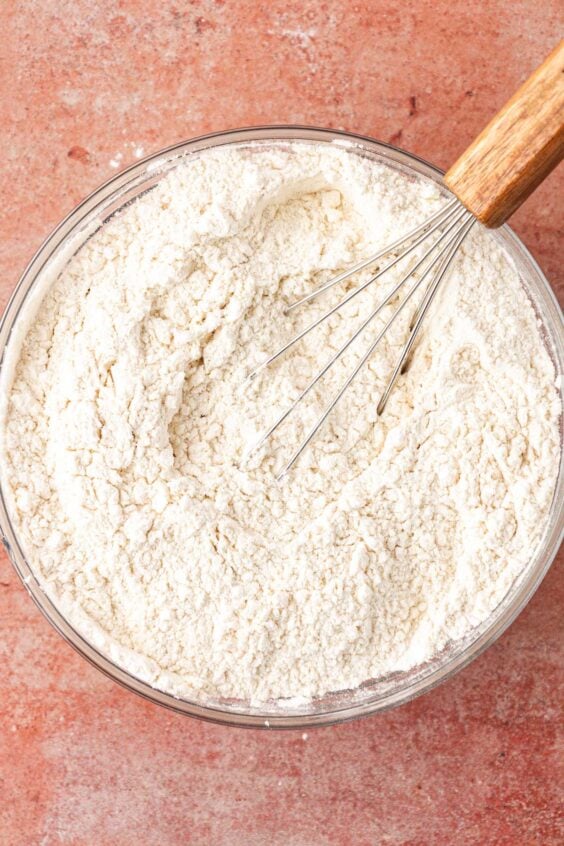 Dry ingredients for cookies being whisked in a bowl.