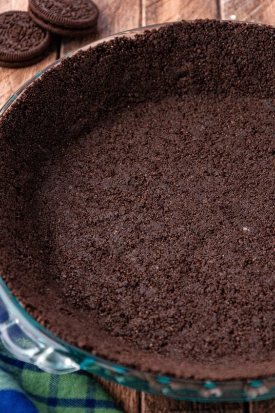 Oreo crumbs pressed into a pie dish.