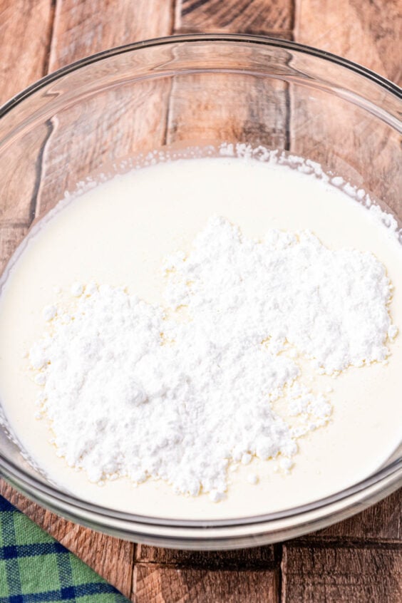 Heavy cream and powdered sugar in a bowl ready to be whipped.