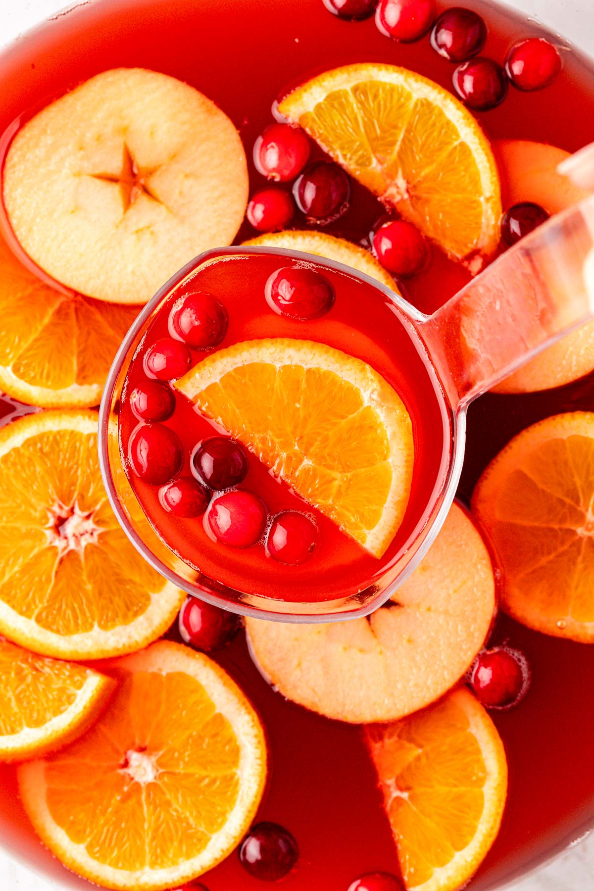 A ladle scooping Thanksgiving punch out of a bowl.