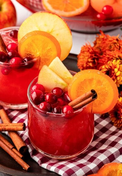 Close up of a glass filled with Thanksgiving punch and garnishes.