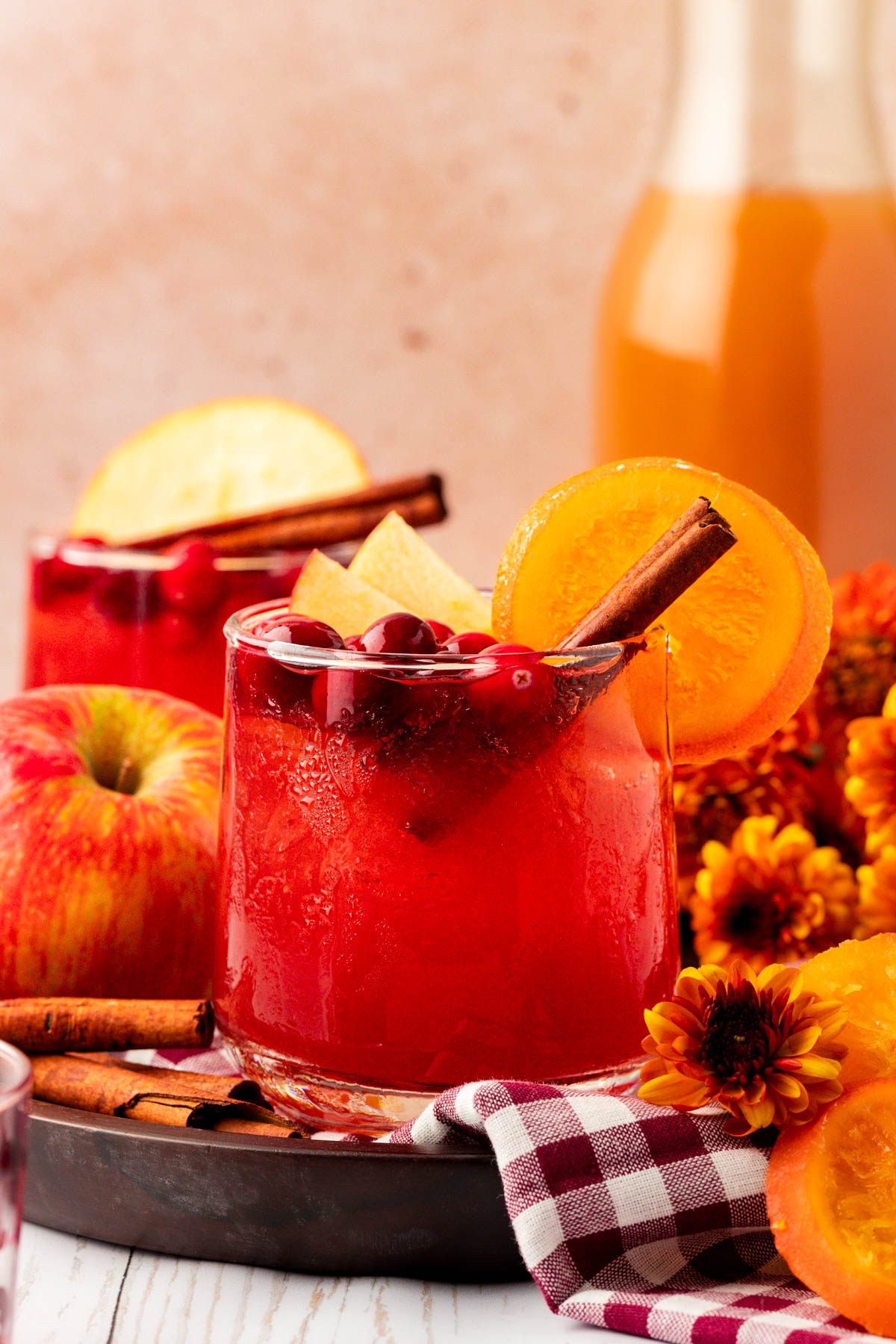 Close up of a glass of red Thanksgiving punch on a table with decorations.