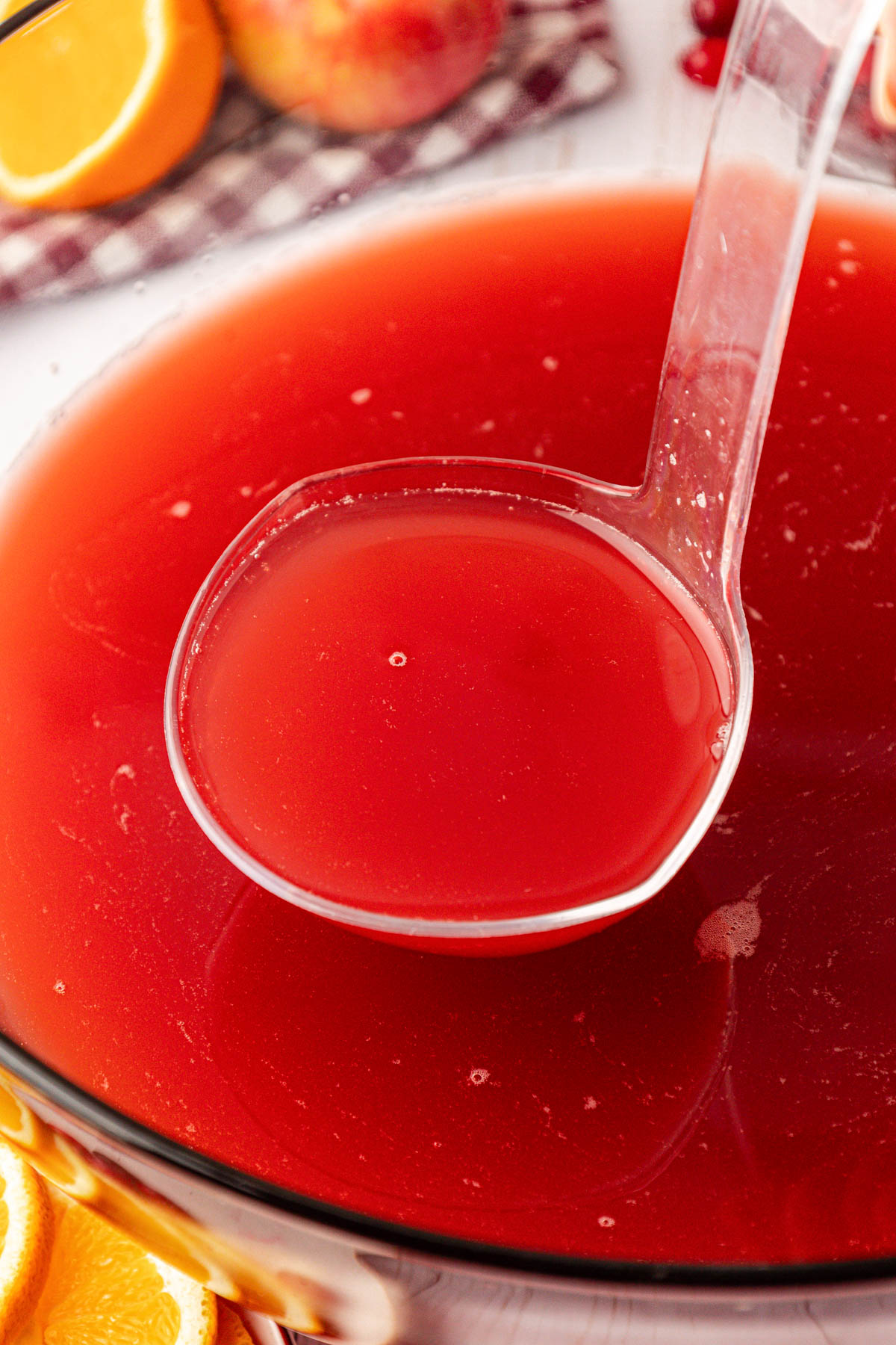 A ladle scooping punch out of a bowl.