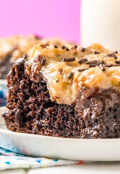 This German Chocolate Poke Cake takes the classic dessert recipe to a whole new level with a tender chocolate cake soaked in sweetened condensed milk and topped with a rich chocolate ganache and sweet coconut pecan frosting!