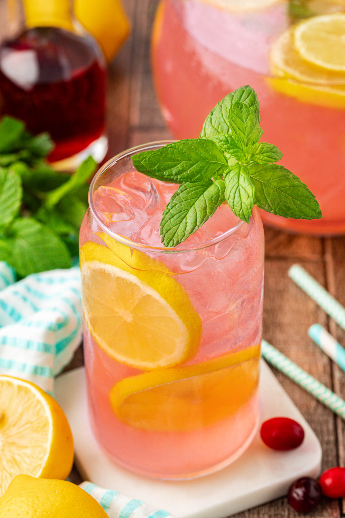 A glass of pink lemonade on a table.