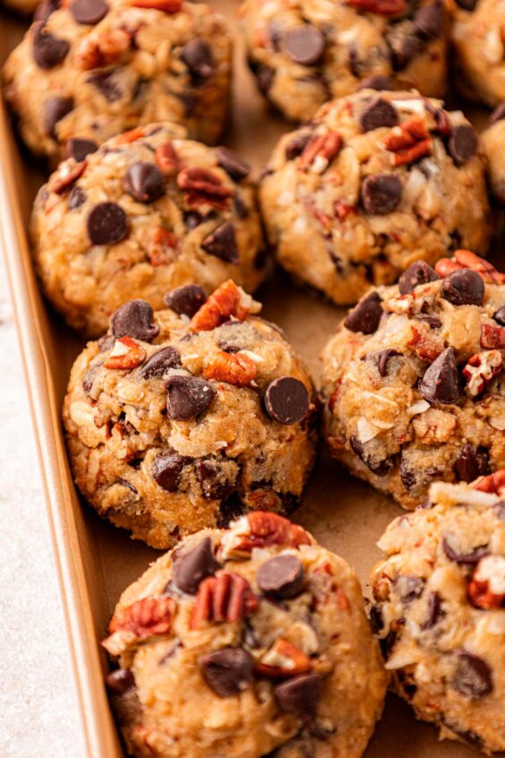 Balls of cowboy cookie dough on a pan.