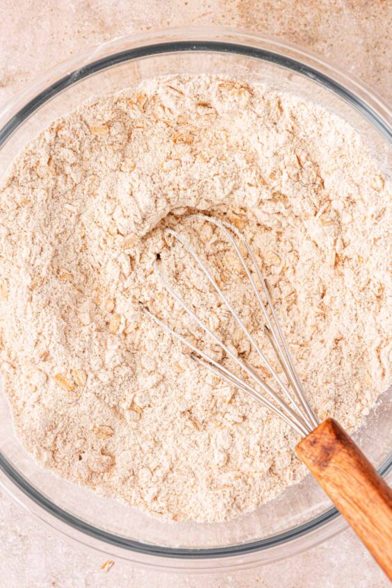 Dry ingredients for cowboy cookies being whisked together in a bowl.