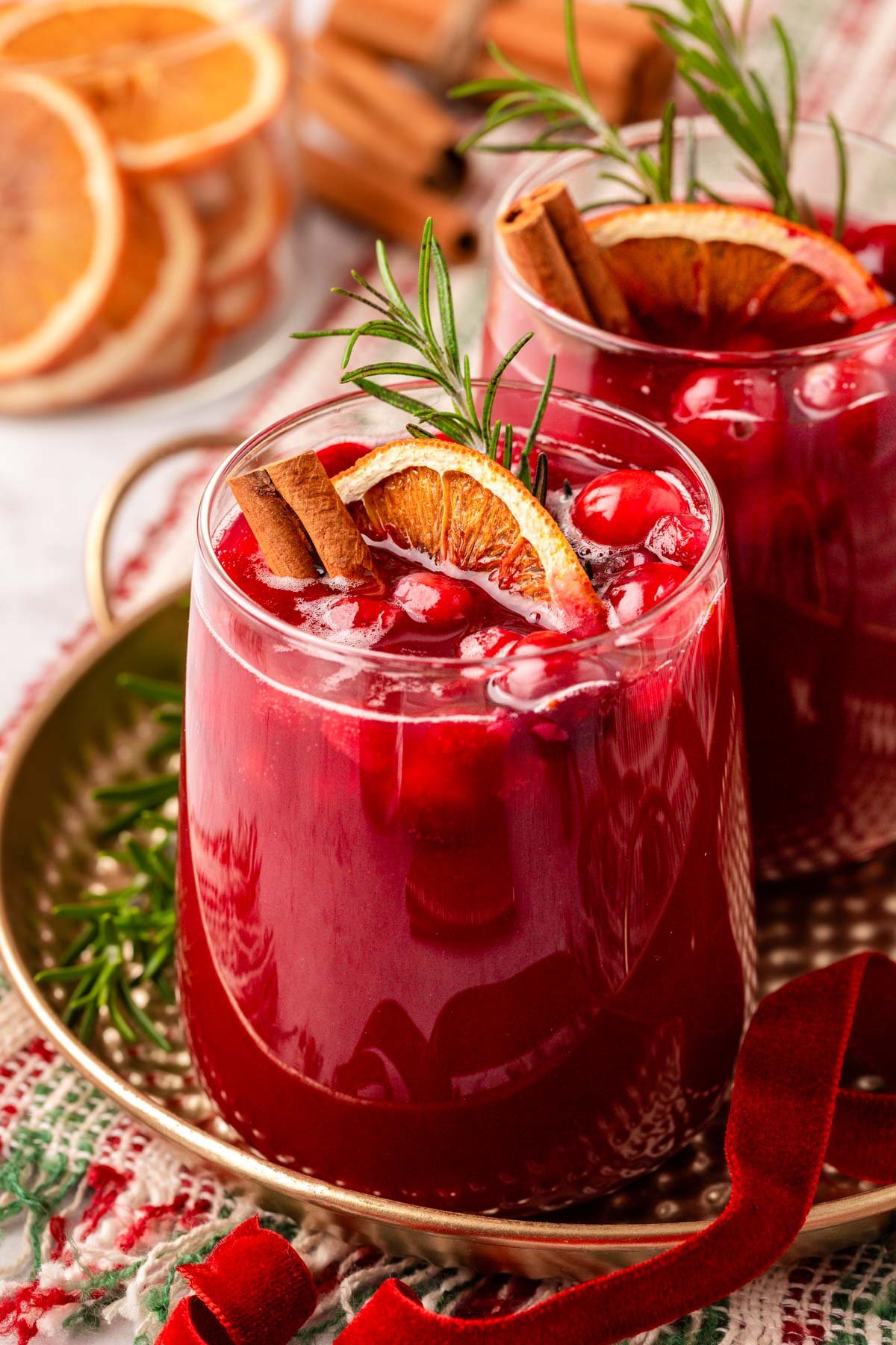 Close up of two glasses of Christmas punch on a gold plate.