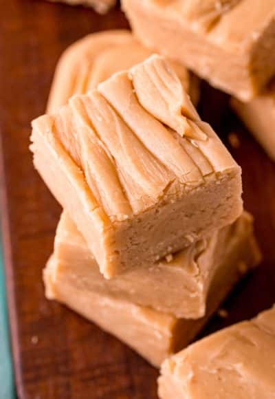 Close up photo of peanut butter fudge stacked on a wooden board.