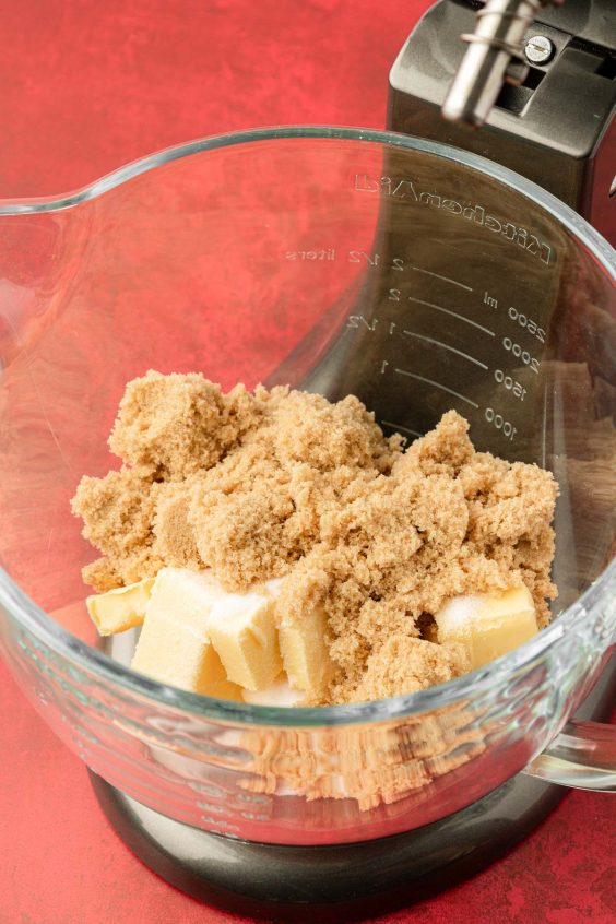 Butter and sugar in a glass kitchen aid mixing bowl.