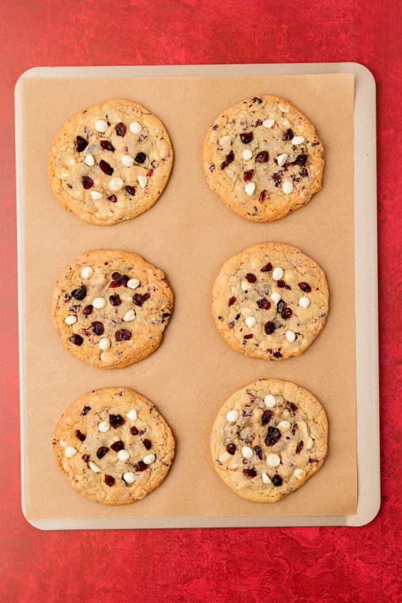 Overhead photo of cranberry white chocolate cookies on a baking pan.