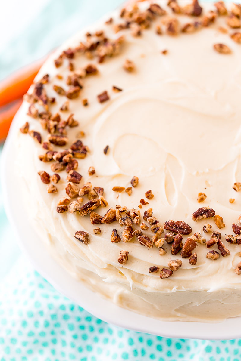 Whole carrot cake topped with chopped pecans.