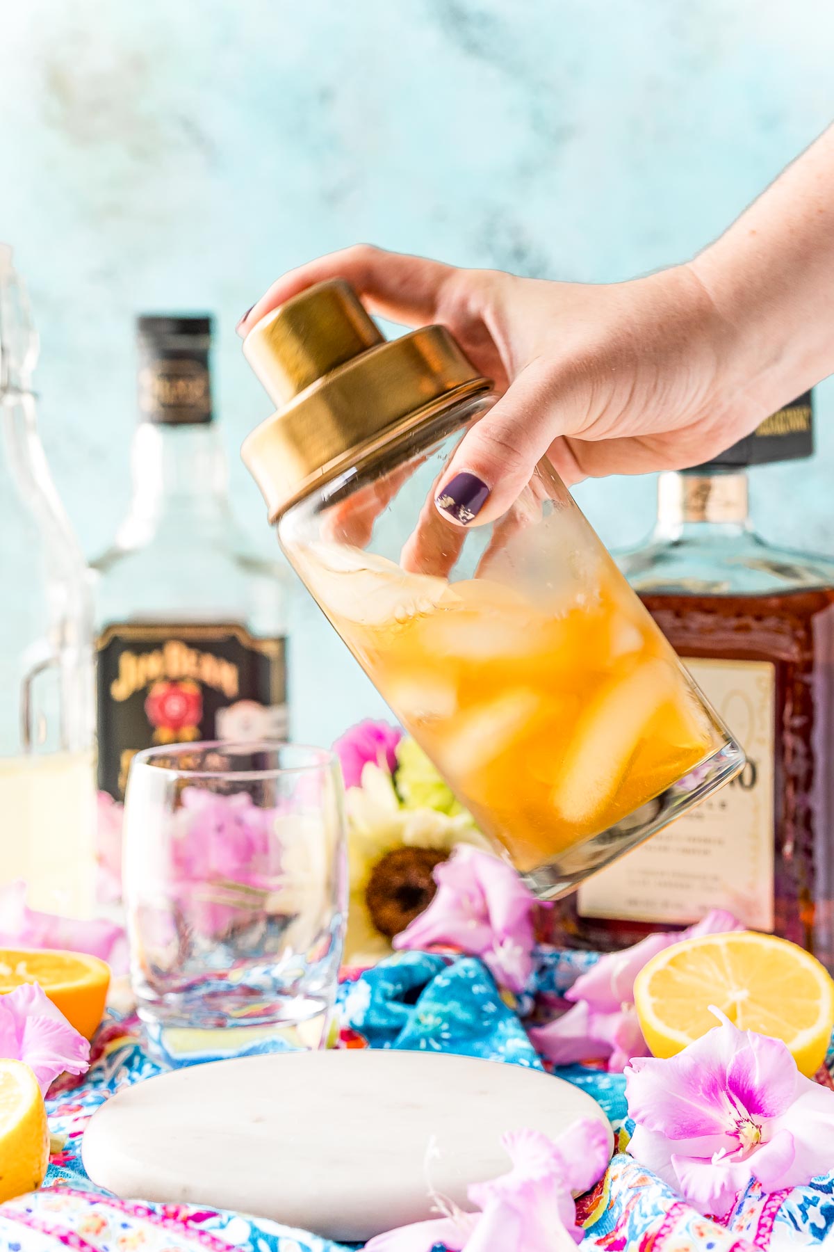 A cocktail shaker being shaken to make an Amaretto sour.