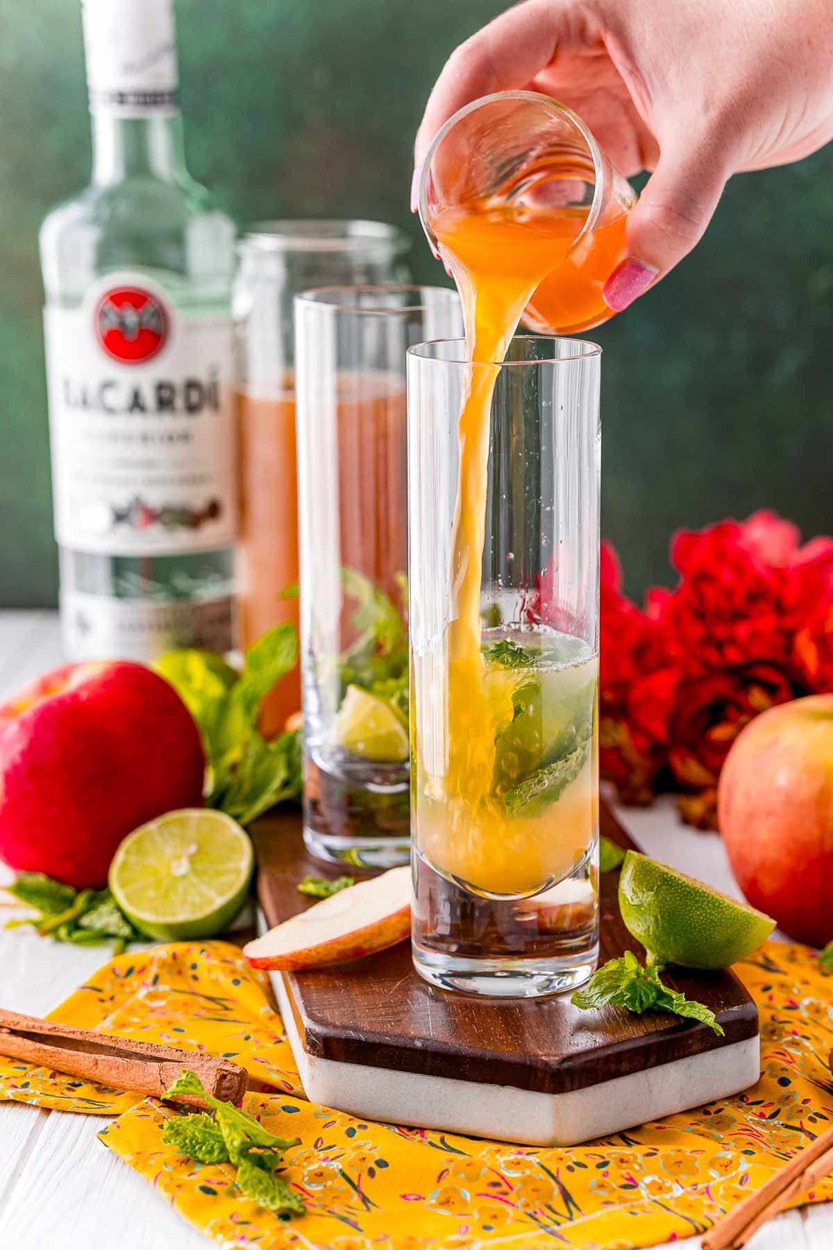 Cider being poured into a tall cocktail glass.