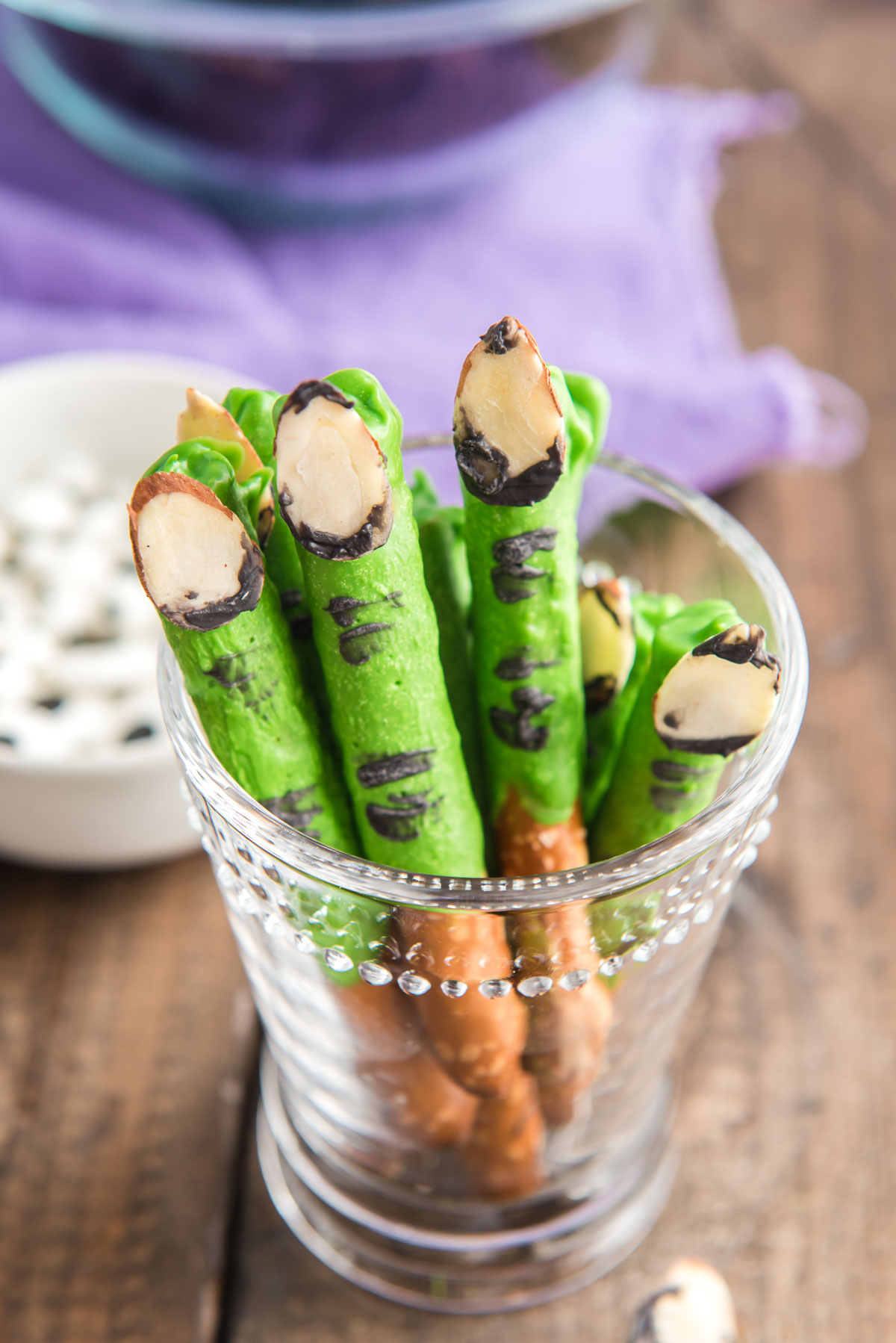 Halloween monster finger pretzels in a clear glass.