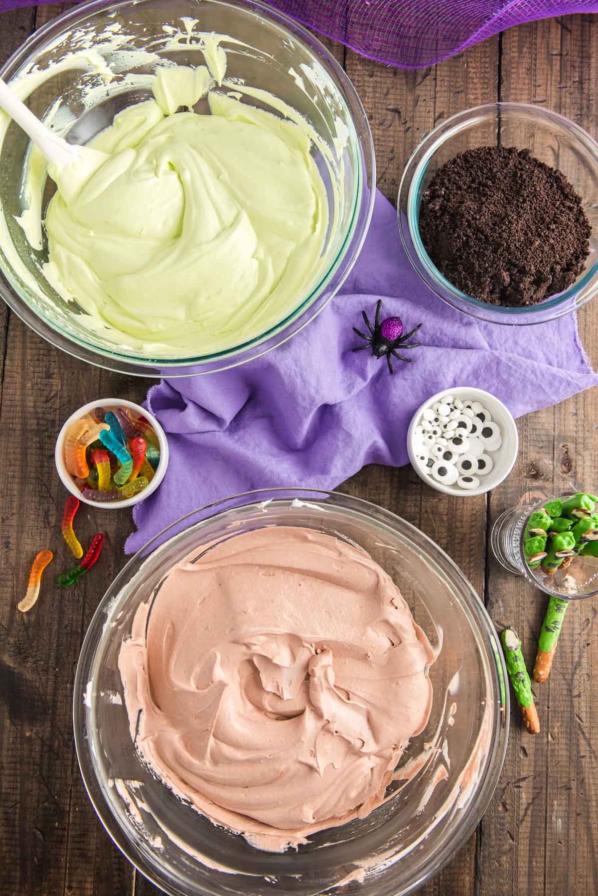 Overhead photo of  bowls of pudding and cool whip and cookie crumbs to make dirt cups.