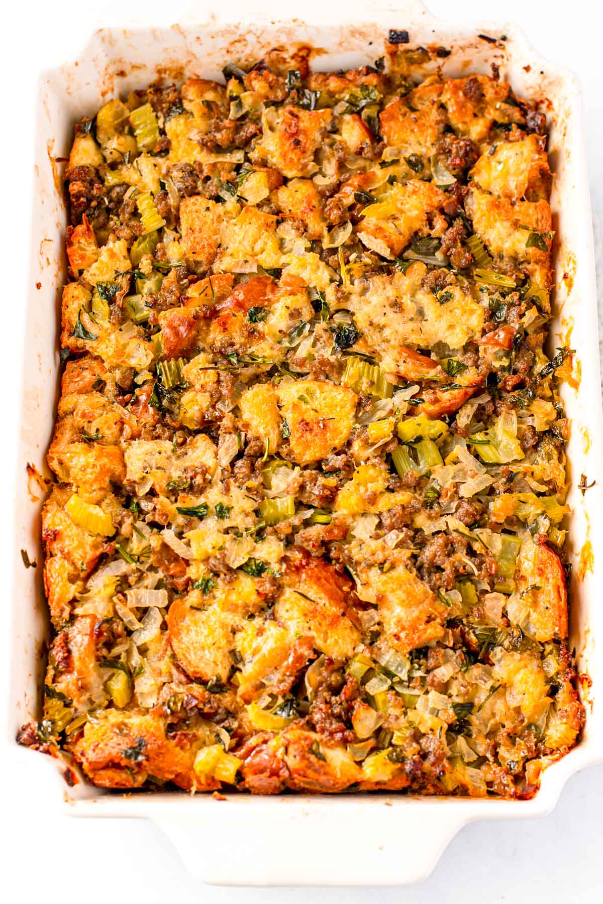 Close up photo of thanksgiving dressing in a white baking dish.