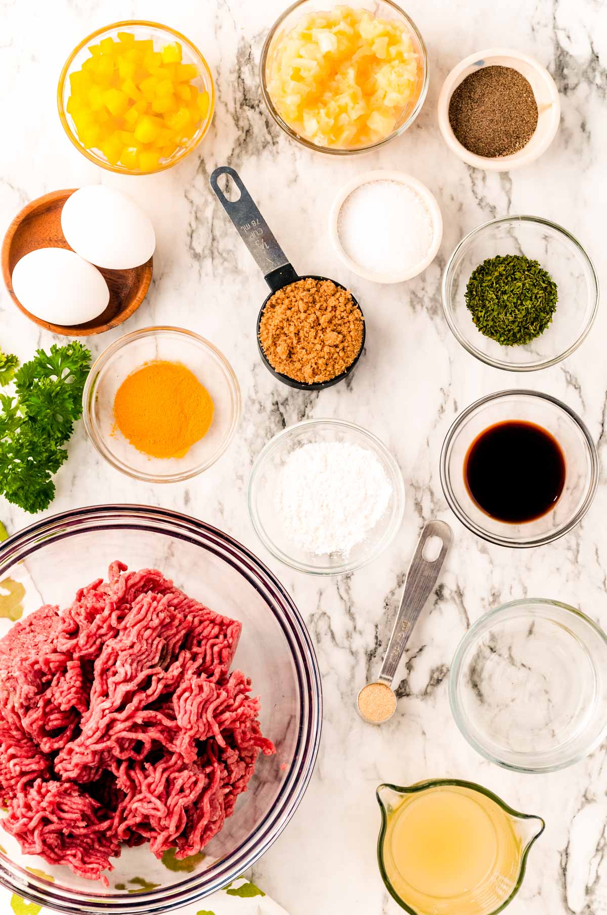 Overhead photo of ingredients prepped on a marble table to make sweet and sour meatballs.