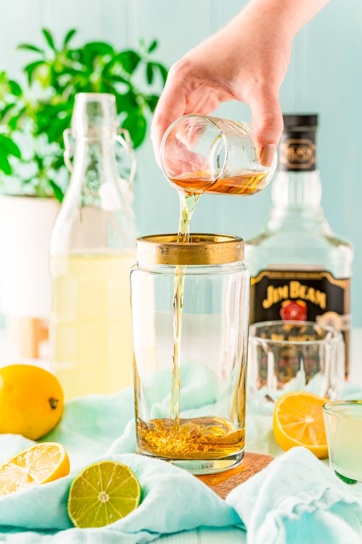 Bourbon being added to a cocktail shaker.