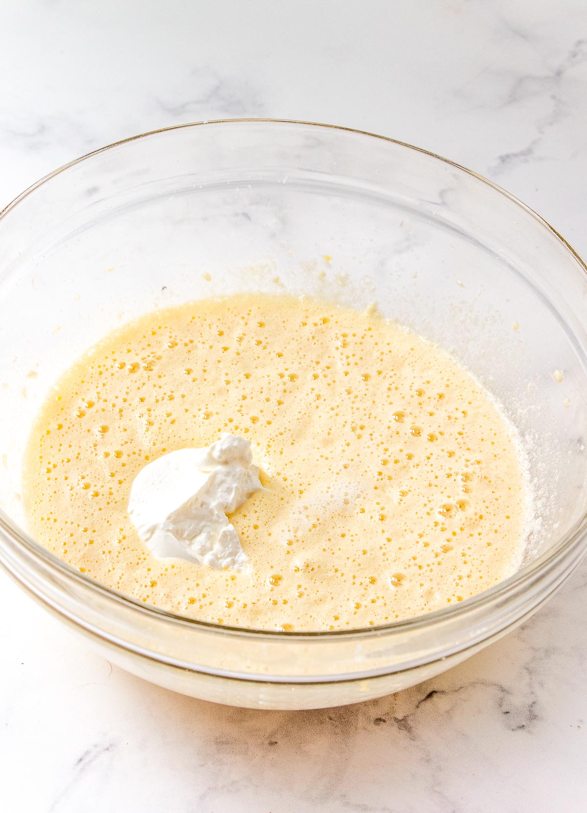 Quick bread batter being made in a glass mixing bowl.