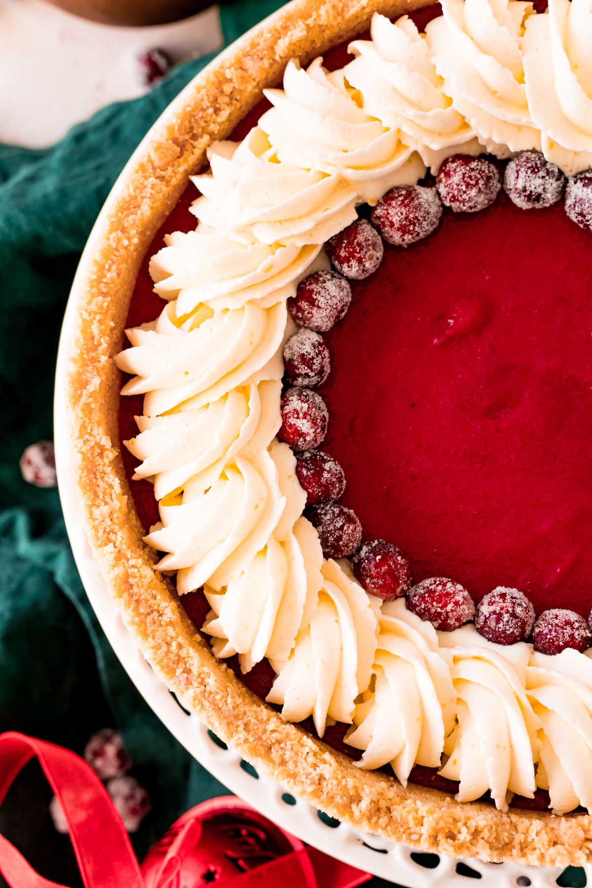 Overhead photo of a cranberry pie with whipped cream and sugared cranberries.