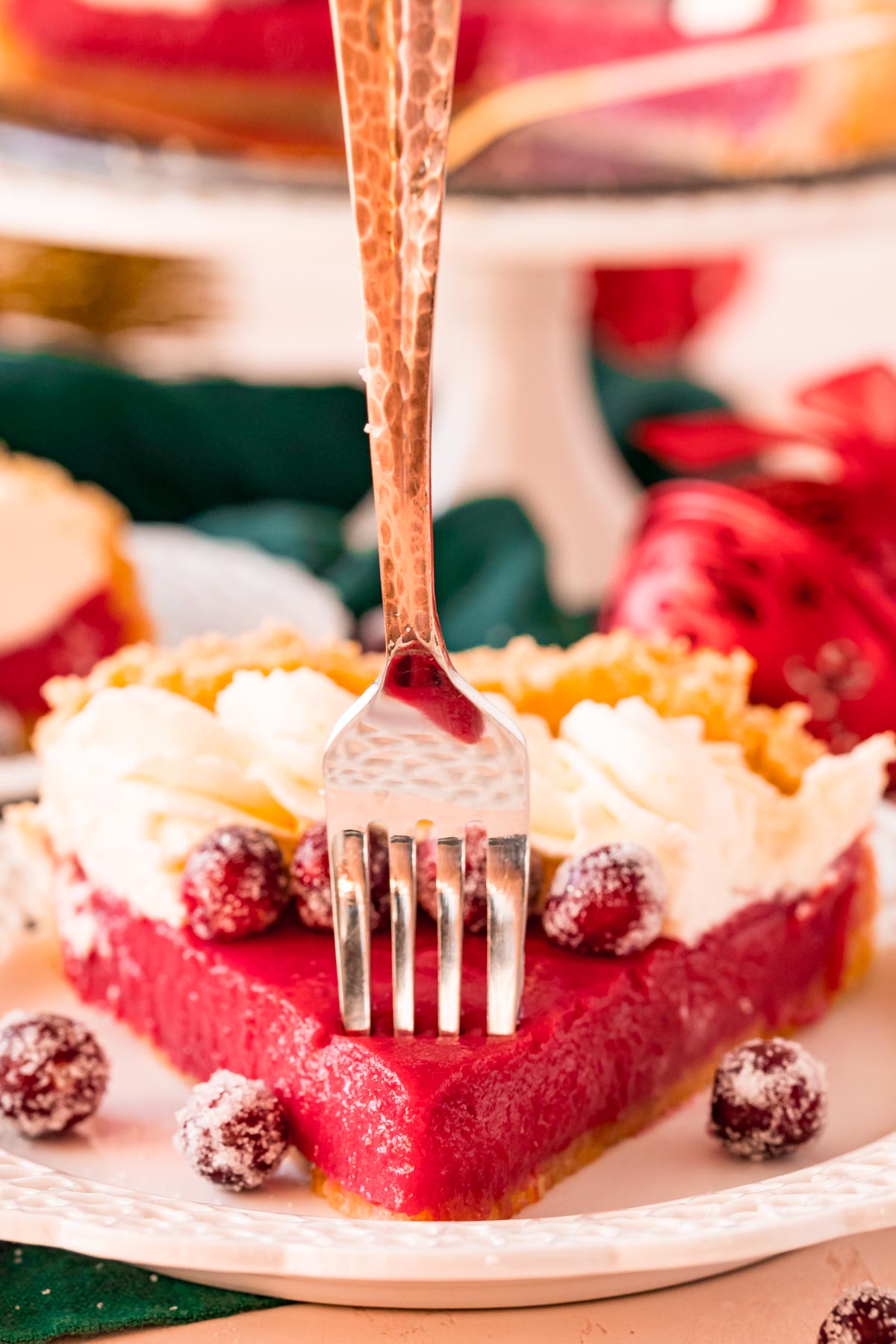 A fork taking a bite out of a cranberry pie.