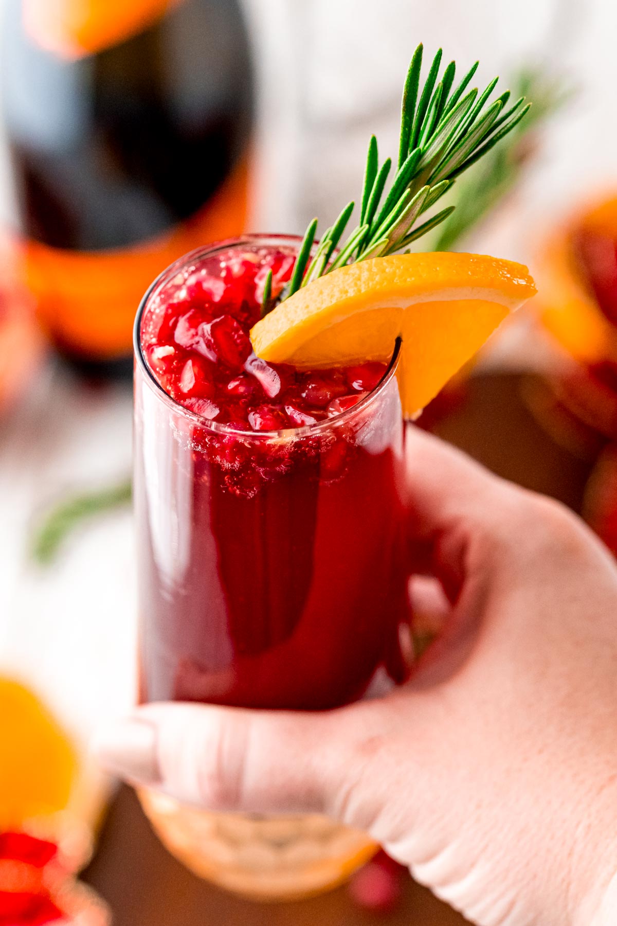 Woman's hand holding a mimosa to the camera.