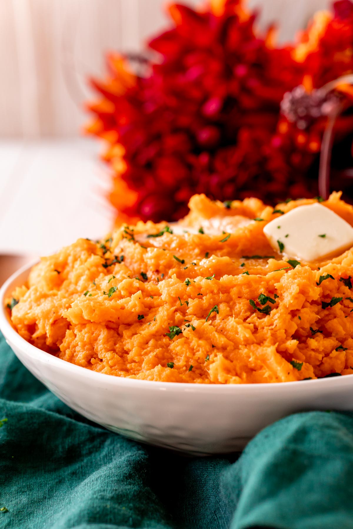 Close up photo of a white bowl filled with sweet potato mash.