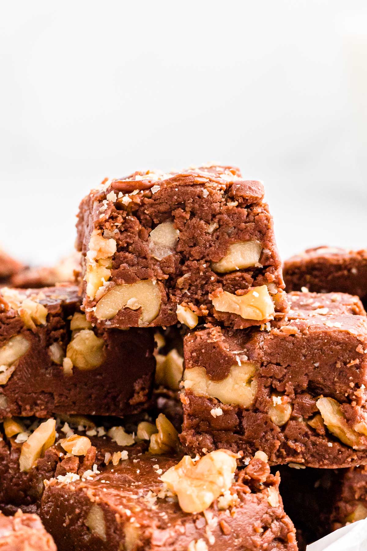 Close up photo of a few pieces of fudge stacked on top of each other.