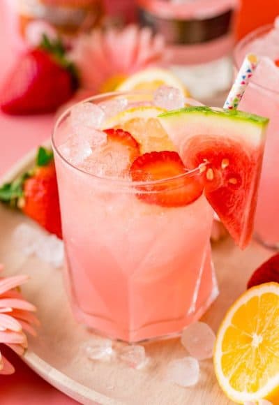 Close up photo of a glass of hippie juice garnished with watermelon and strawberries.