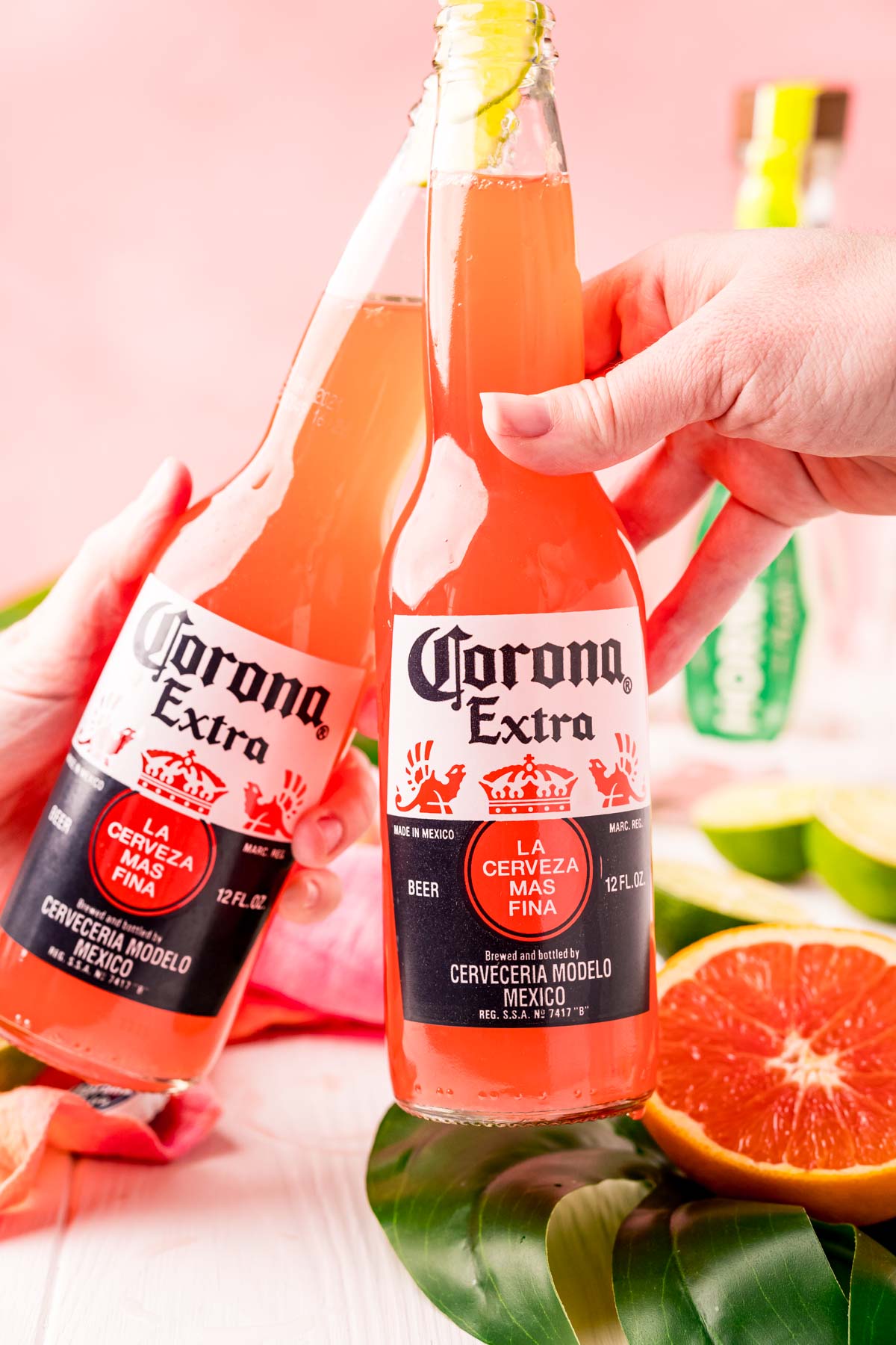 Two Corona bottles with Corona sunrises in them cheering.