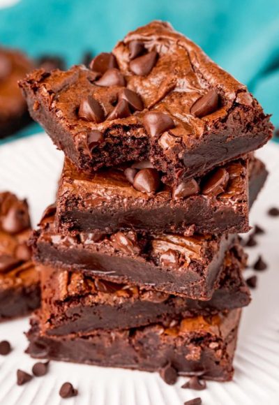 close up photo of a stack of brownies with the top one missing a bite.