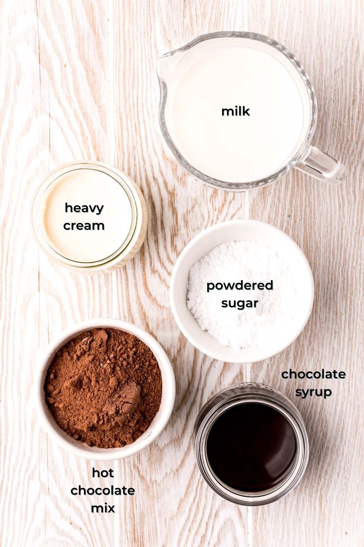 Overhead photo of ingredients to make frozen hot chocolate prepared on a wooden table.