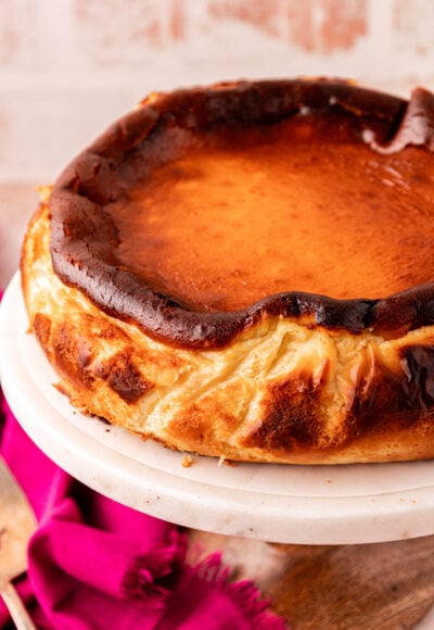 Close up of a whole basque cheesecake on a cake stand.