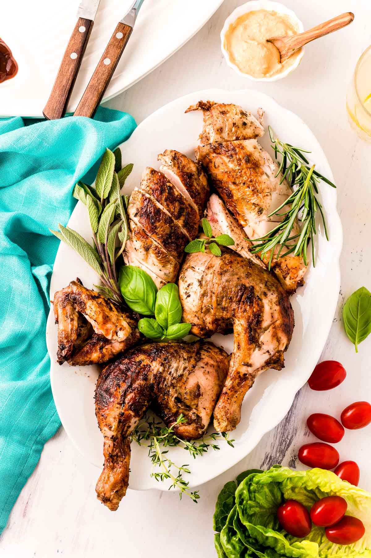 Overhead photo of a spatchcock grilled chicken that has been broken down and plated on a serving platter.