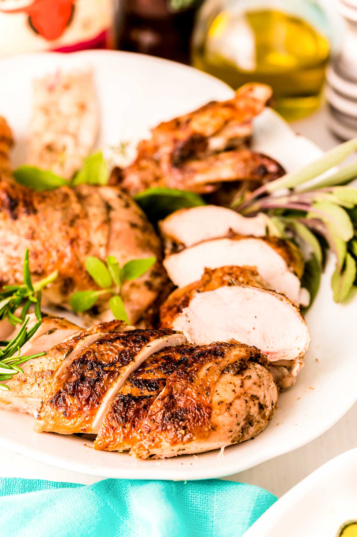 Close up photo of a white platter with a broken down grilled chicken on it.