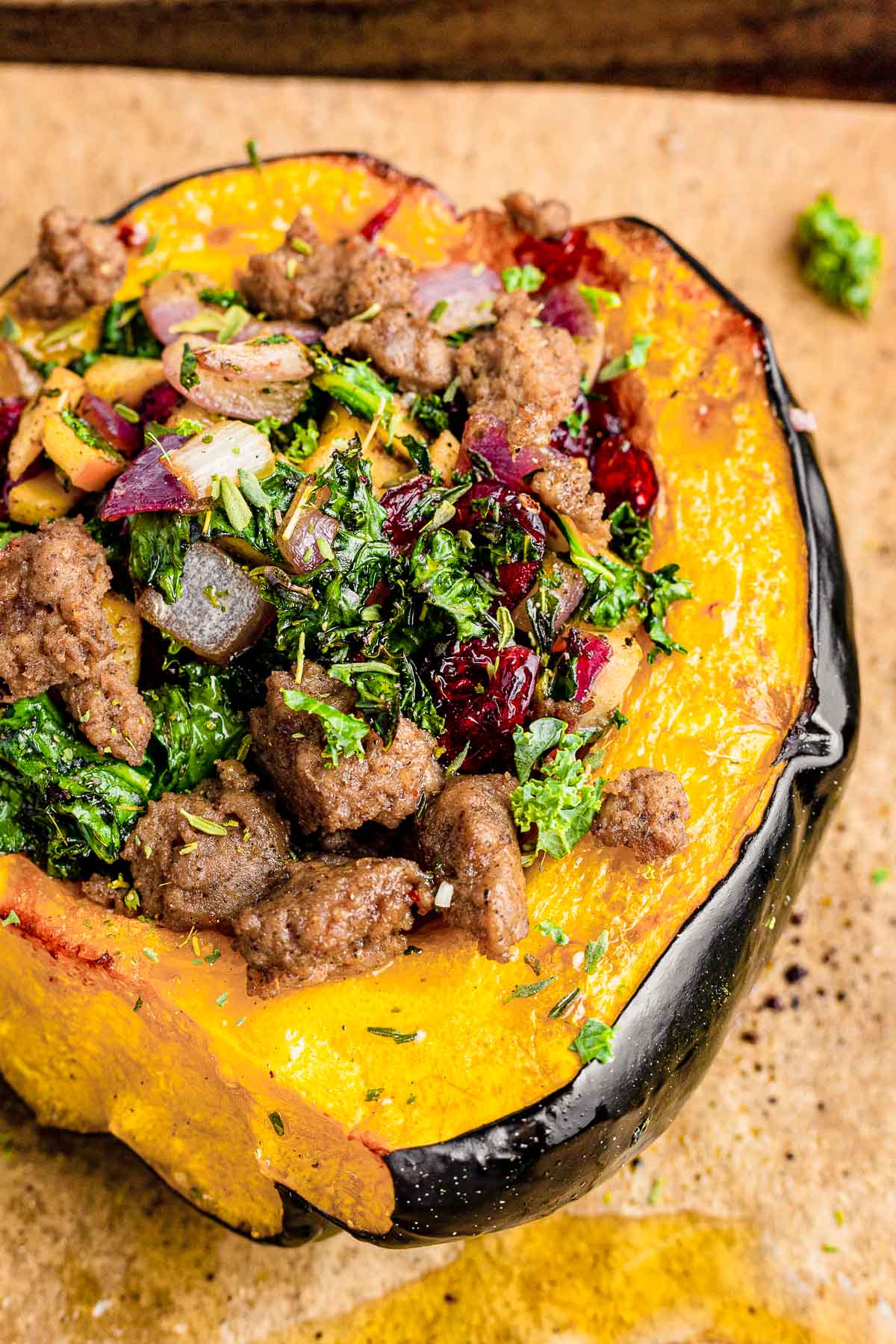 Close up photo of stuffed acorn squash on parchment paper.