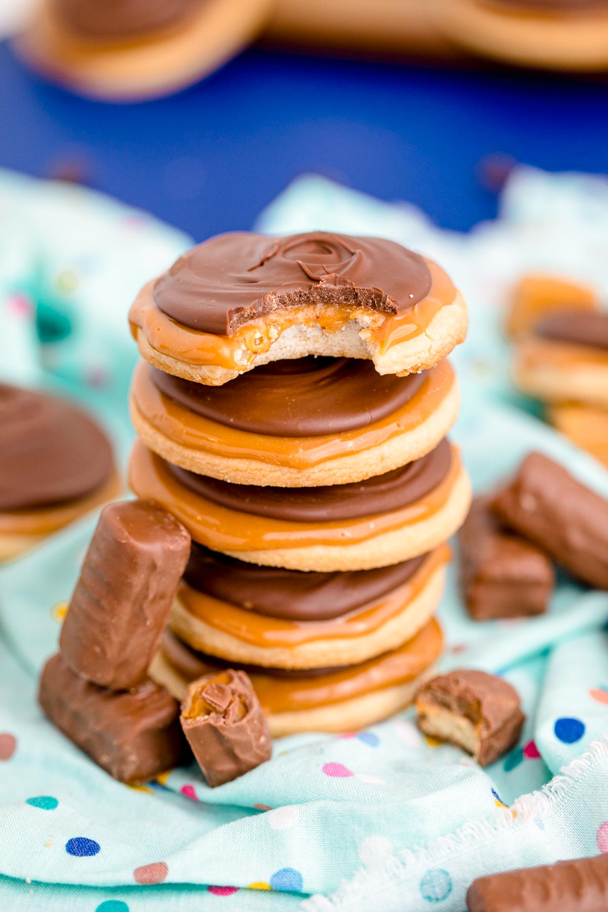 Close up photo of a stack of 4 twix cookies on a light blue napkin.