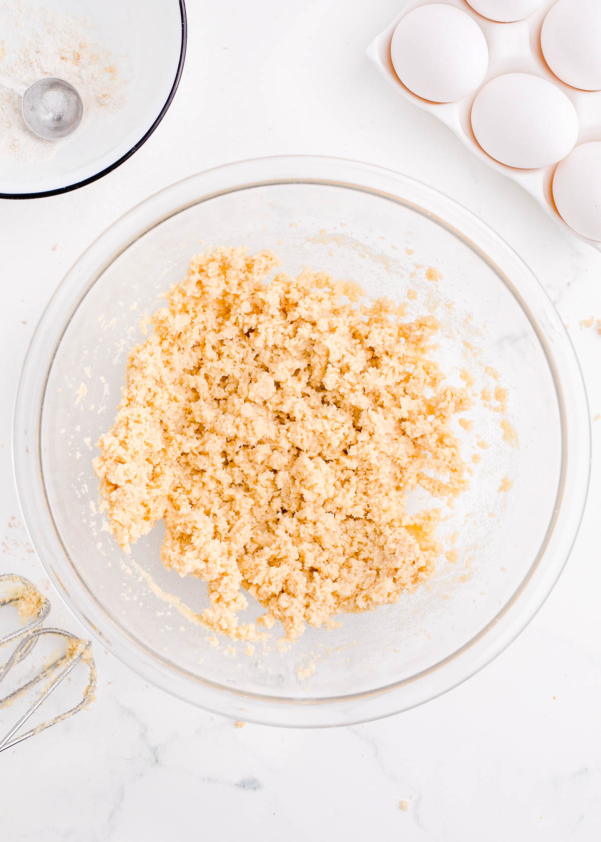 Butter and sugar creamed together in a glass mixing bowl.