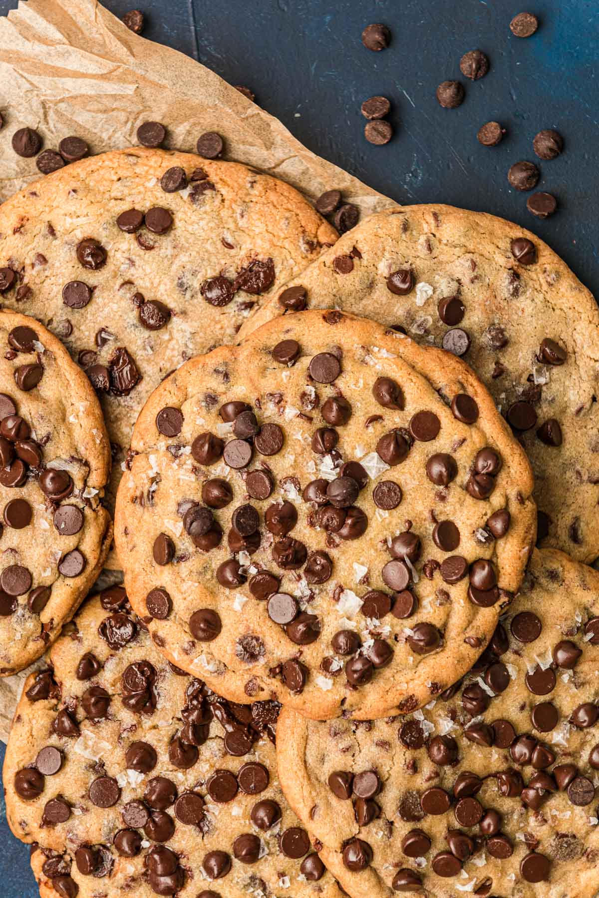 Giant chocolate chip cookies piled on a serving tray.