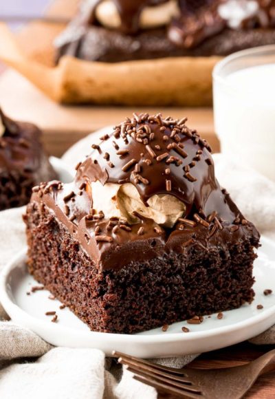 A slice of buckeye cake on a white plate with a glass of milk in the background.