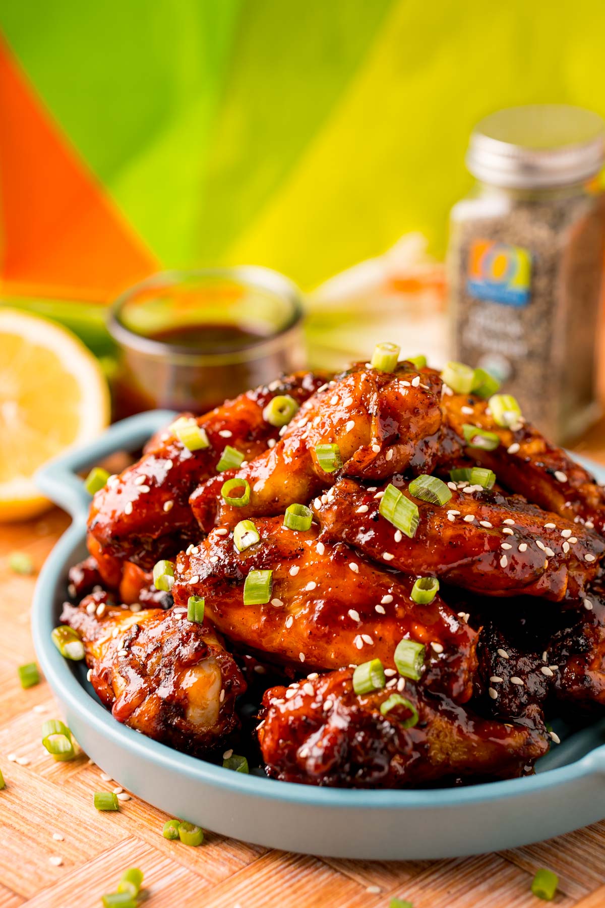 Close up photo of grilled Korean BBQ chicken wings on a blue serving plate.