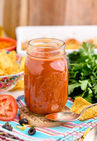 A jar of homemade enchilada sauce on a table.